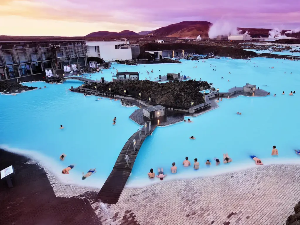 The Blue Lagoon in Iceland, a geothermal spa with milky-blue, mineral-rich waters surrounded by black lava fields and rising steam, offering a surreal and relaxing atmosphere.
