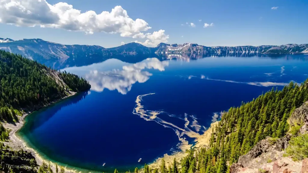 Crater Lake in Oregon, USA, a stunning, deep blue caldera lake formed in the crater of an ancient volcano, surrounded by steep cliffs and pristine wilderness.