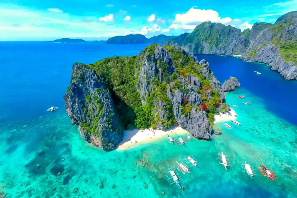Palawan, Philippines, a tropical paradise with crystal-clear waters, dramatic limestone cliffs, hidden lagoons, and white-sand beaches surrounded by lush greenery.