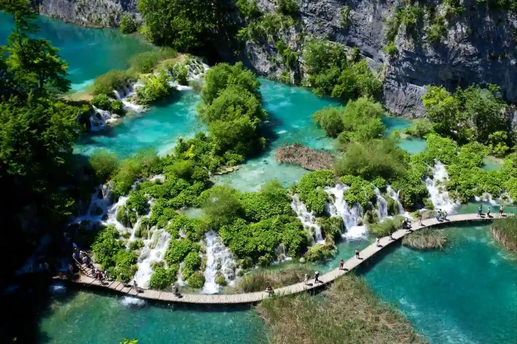 Plitvice Lakes National Park in Croatia, a series of cascading turquoise lakes and waterfalls surrounded by lush forest and wooden walking trails.