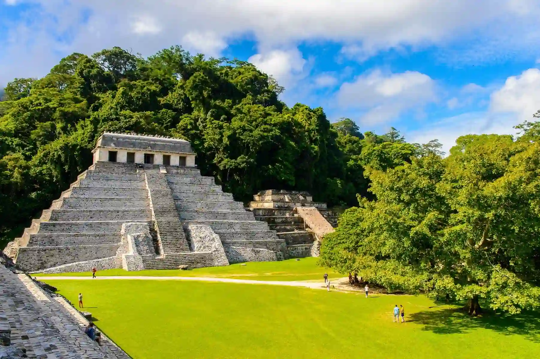 The Temple of the Inscriptions at Palenque, Mexico, an ancient Mayan pyramid with detailed carvings and inscriptions, serving as the tomb of King Pakal, surrounded by dense jungle.
