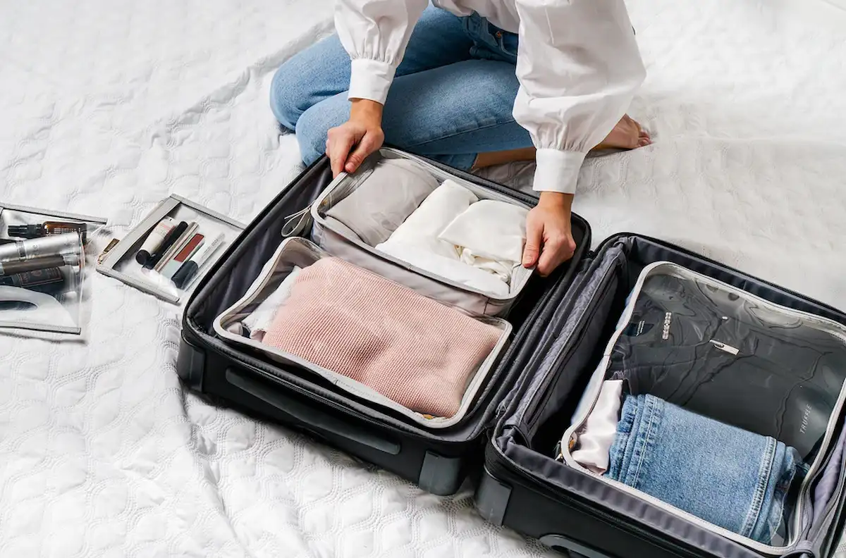 Packing a suitcase with organized clothes.
