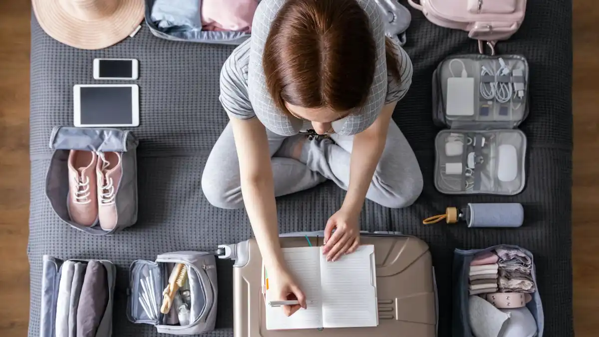 Woman organizing travel items thoughtfully.